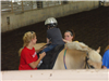 Women assisting child ride horse