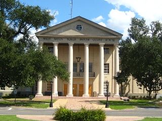 Large courthouse building surrounded by trees